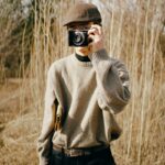 Stylish man in a sweater taking photos in a natural setting in Ankara.