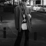 Black and white portrait showcasing street fashion style in a city environment.