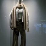 Mannequin wearing stylish winter outfit in a store window display with soft lighting.