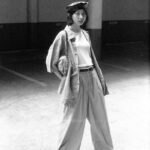 Monochrome photo of a woman in a stylish outfit standing in an industrial environment.